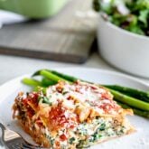 Slice of easy baked vegetable lasagna on a circular white plate.