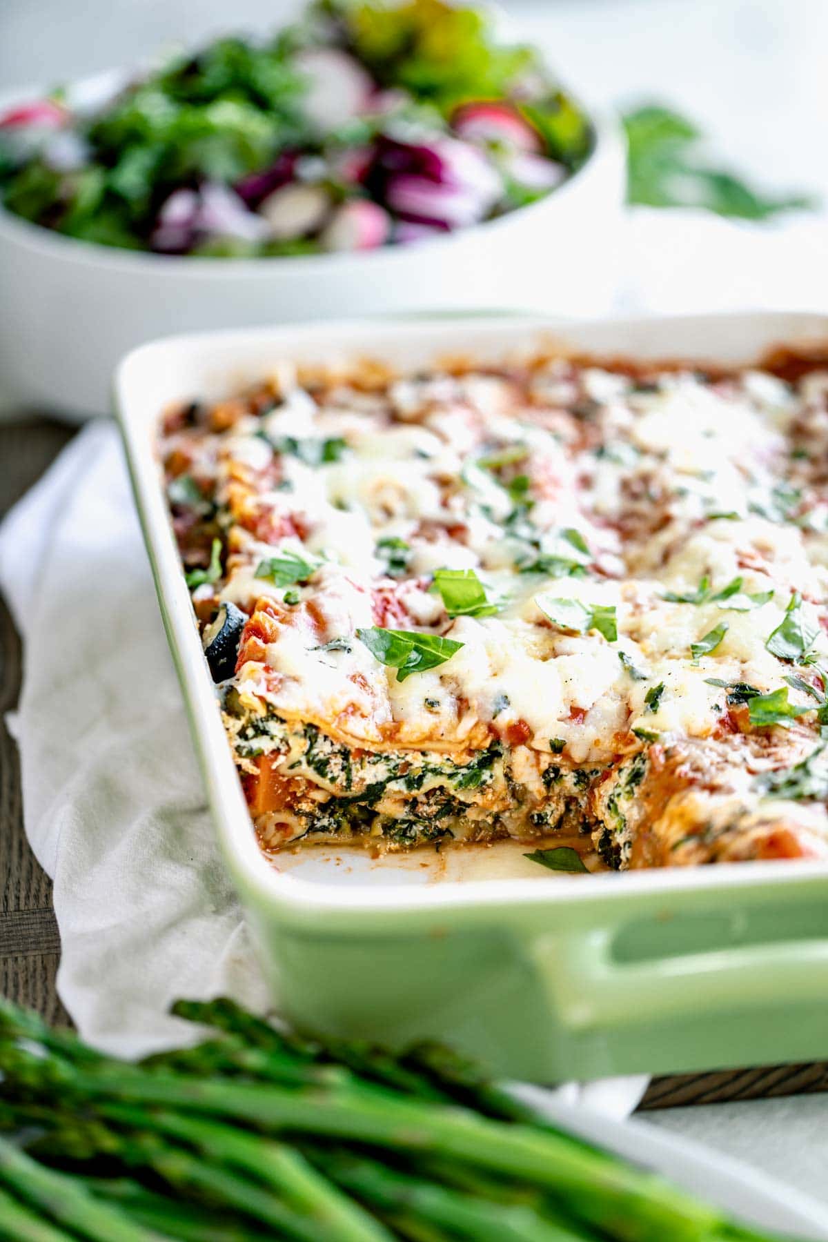 Easy vegetable lasagna in baking dish with slice missing.