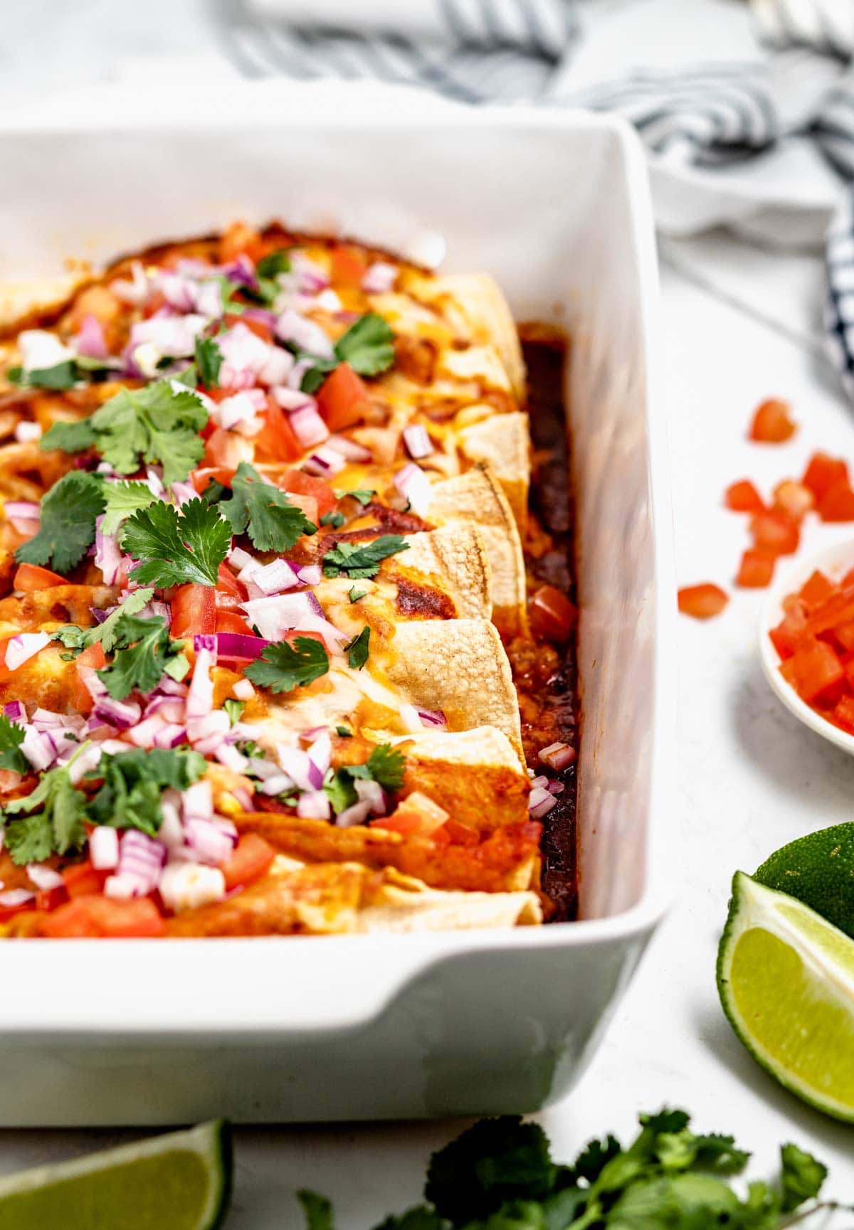 Ground turkey enchiladas in white casserole dish.