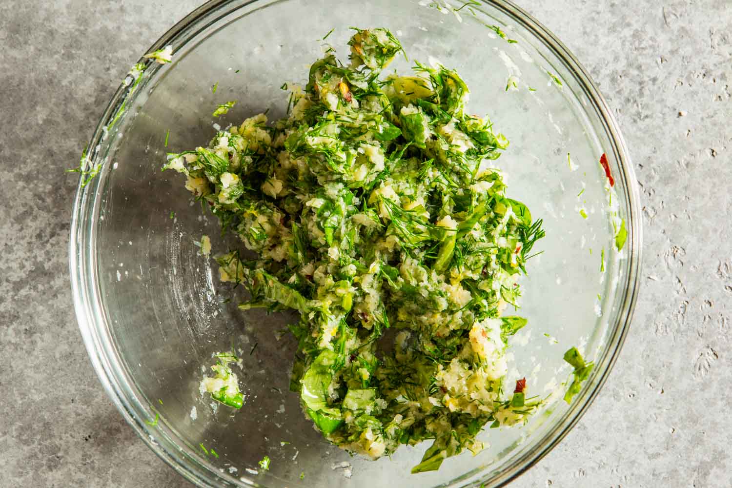 herbs, lemon zest and grated cheese in a small glass bowl