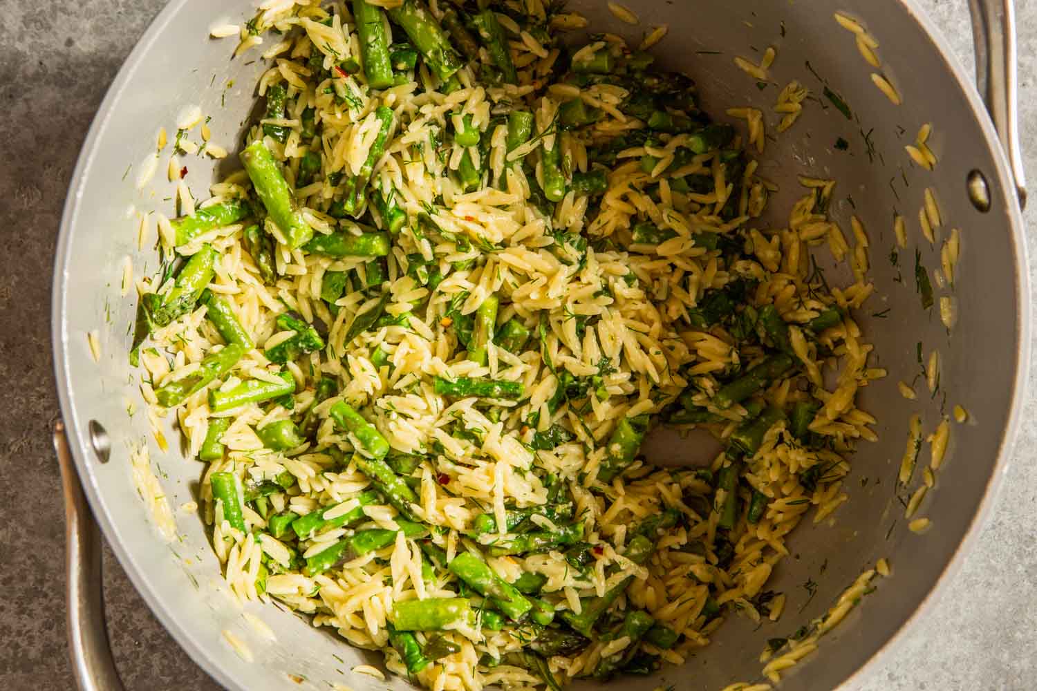 cooked orzo and asparagus in a large gray pot