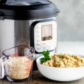 instant pot with a bowl of cooked barley and a measuring cup with uncooked barley