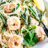 SHRIMP AND ASPARAGUS PASTA UP CLOSE IN A WHITE BOWL