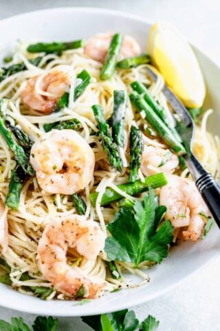 SHRIMP AND ASPARAGUS PASTA UP CLOSE IN A WHITE BOWL