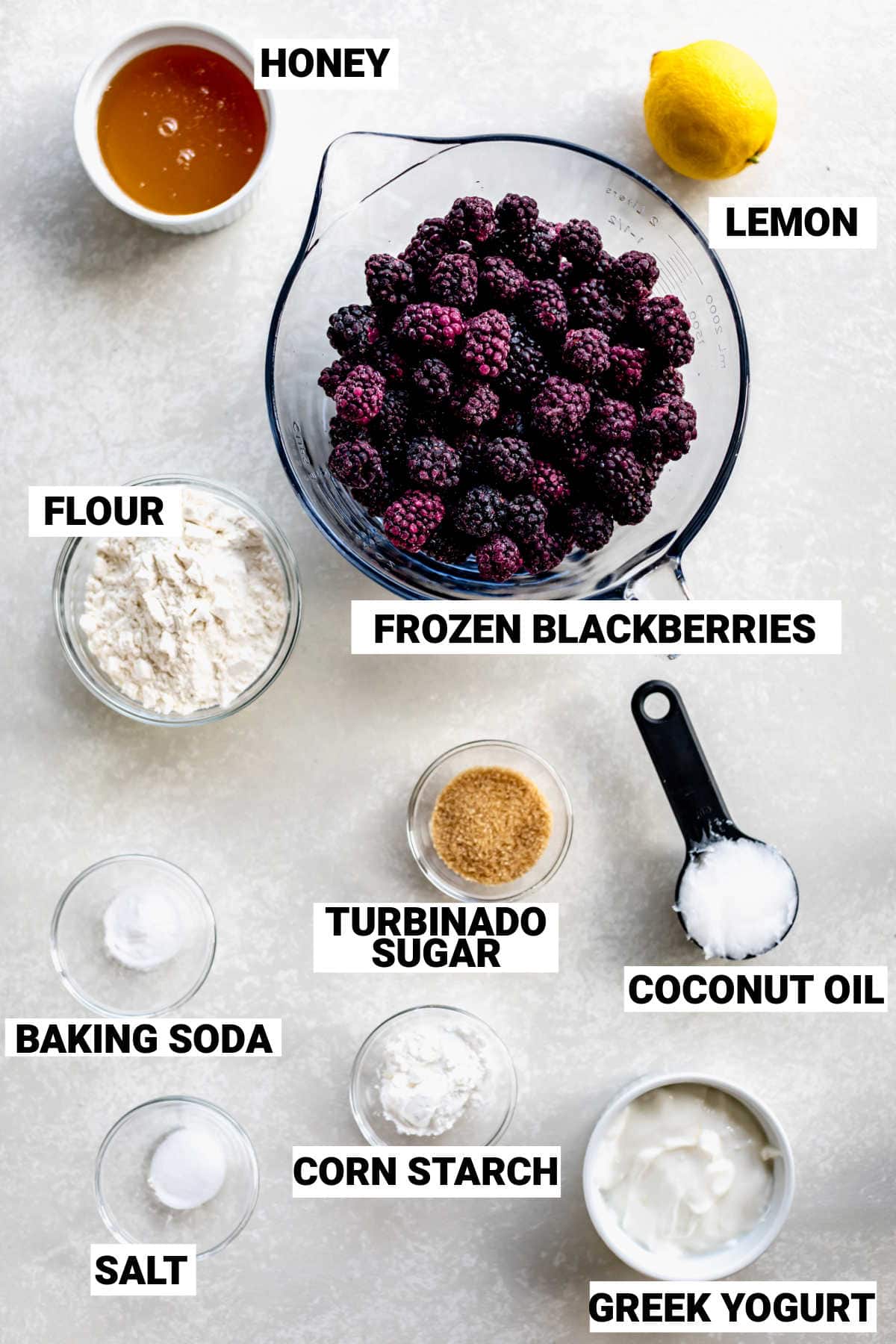 Ingredients for blackberry cobbler in different sized bowls on a table.