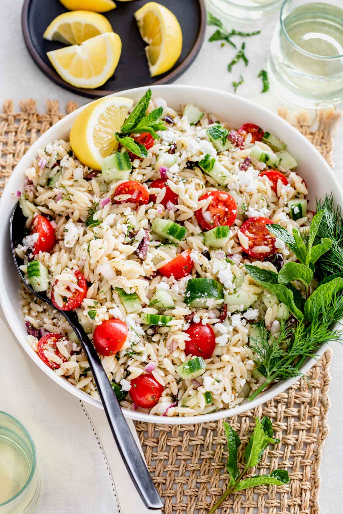 Orzo Pasta salad in a white bowl on a table.