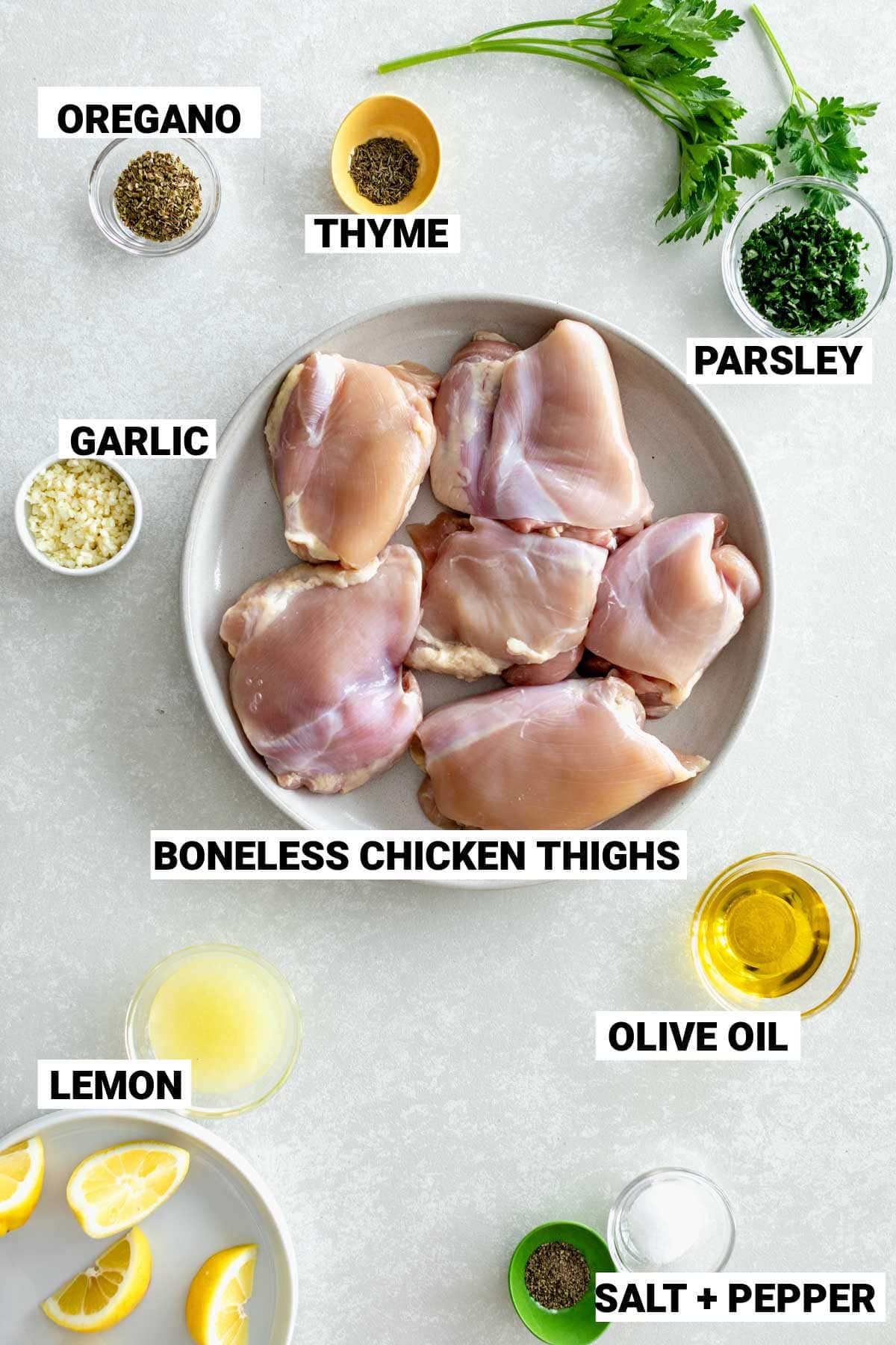 the chicken thighs and other ingredients on a white table with labels