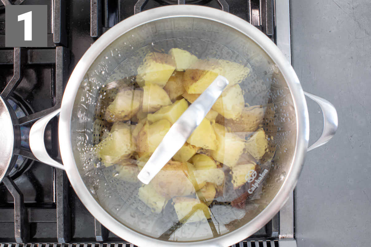 the potatoes in a pot with a steamer basket