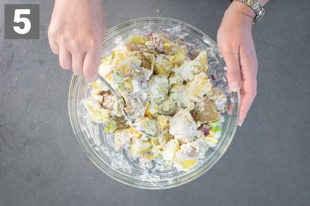 stirring the potato salad together