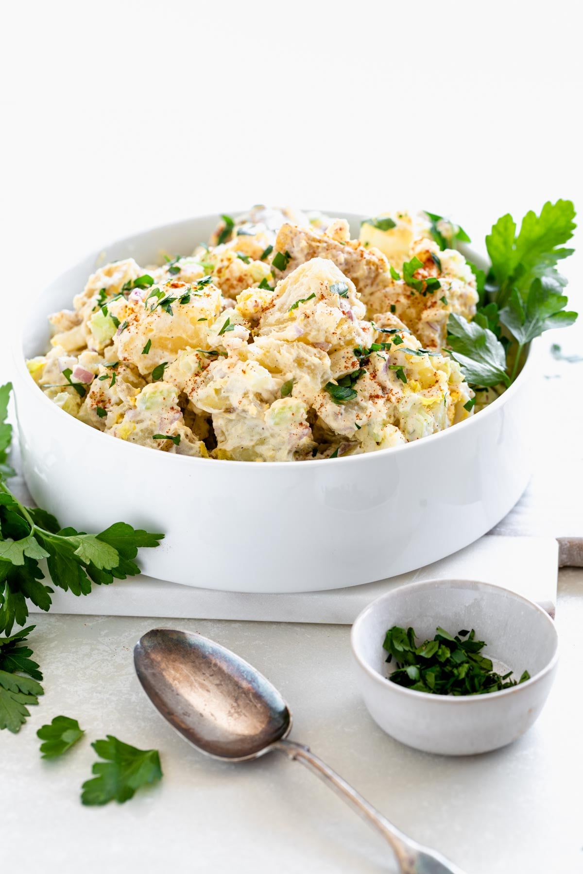 creamy potato salad from the side in a white straight-sided bowl