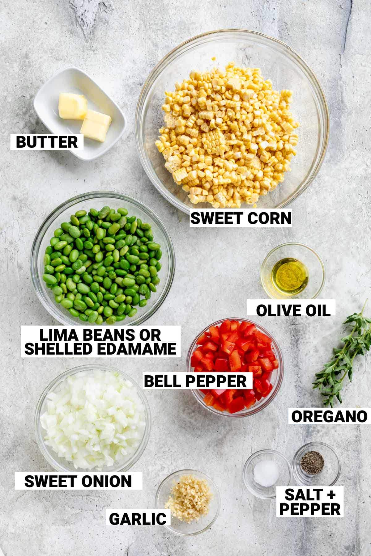 ingredients for corn succotash including butter, sweet corn, lima beans or edamame, bell pepper, onion, oregano, olive oil, garlic, and seasonings