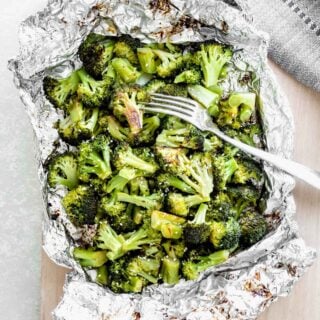 grilled broccoli in foil fresh off the grill with a fork on top