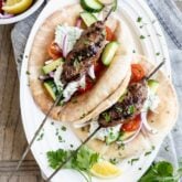 grilled ground turkey kofta kebabs in a pita pocket with tzatziki sauce and garnish