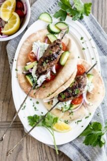 grilled ground turkey kofta kebabs in a pita pocket with tzatziki sauce and garnish