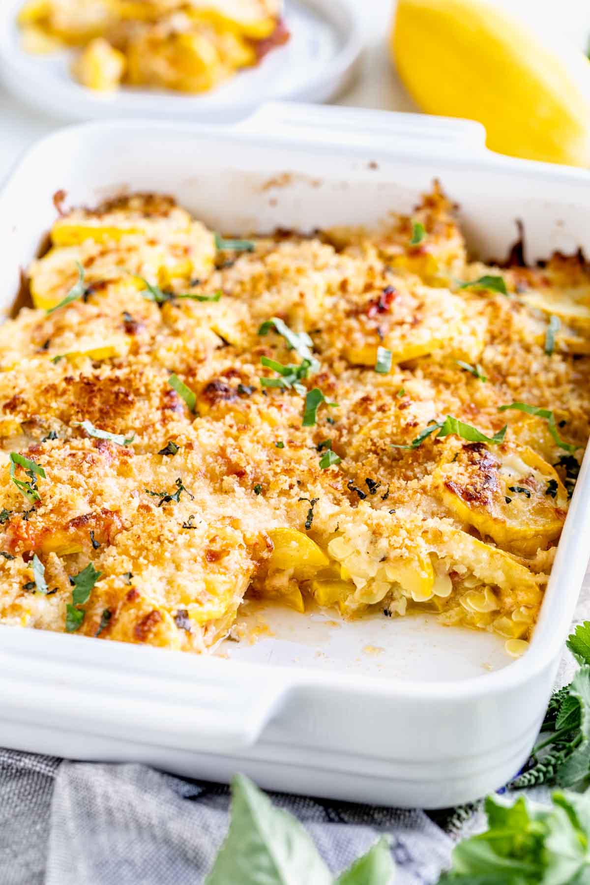 summer squash in a white baking dish topped with crunchy breadcrumbs