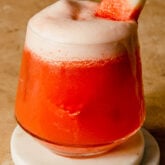 watermelon cocktail in a rocks glass set on two white coasters
