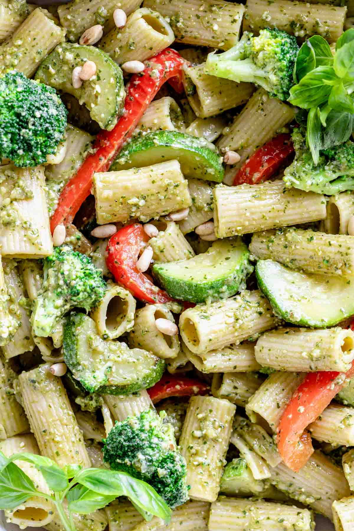 close up shot of rigatoni with pesto and cooked summer vegetables