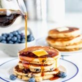 whole wheat blueberry pancakes with maple syrup poured overtop