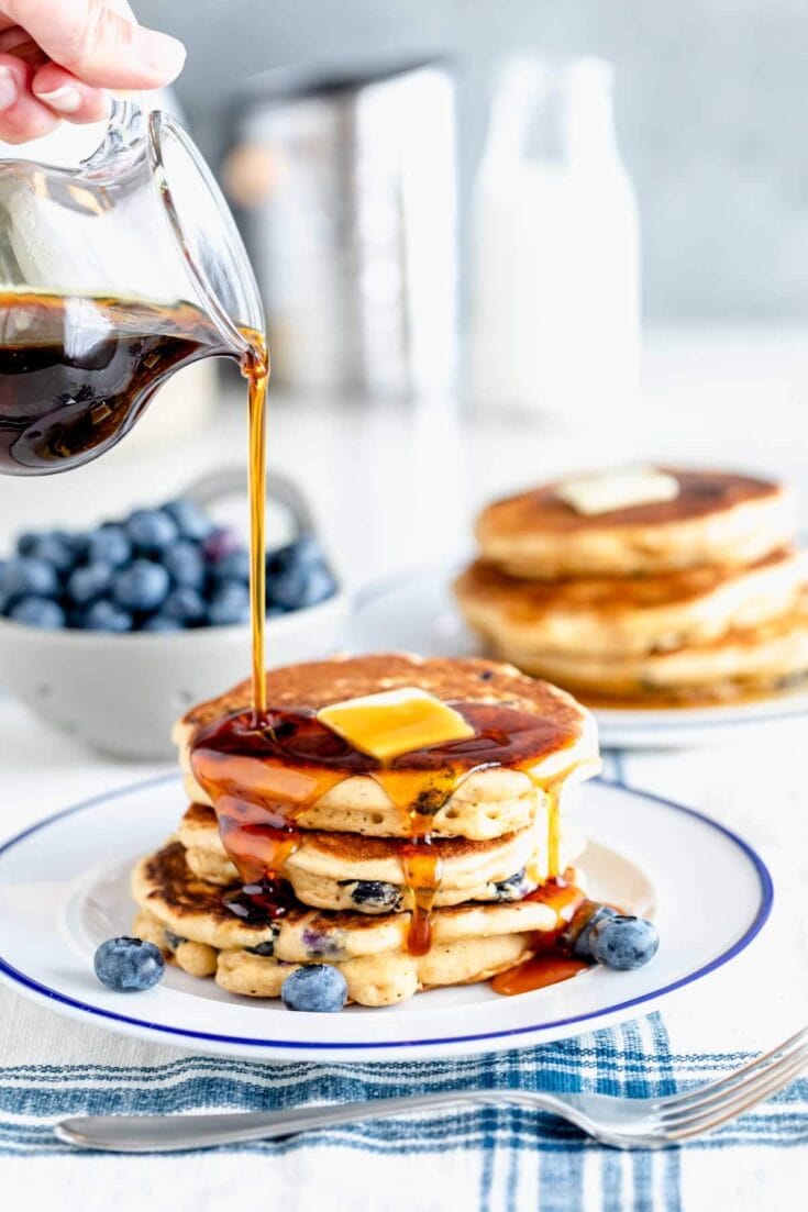 whole wheat blueberry pancakes with maple syrup poured overtop