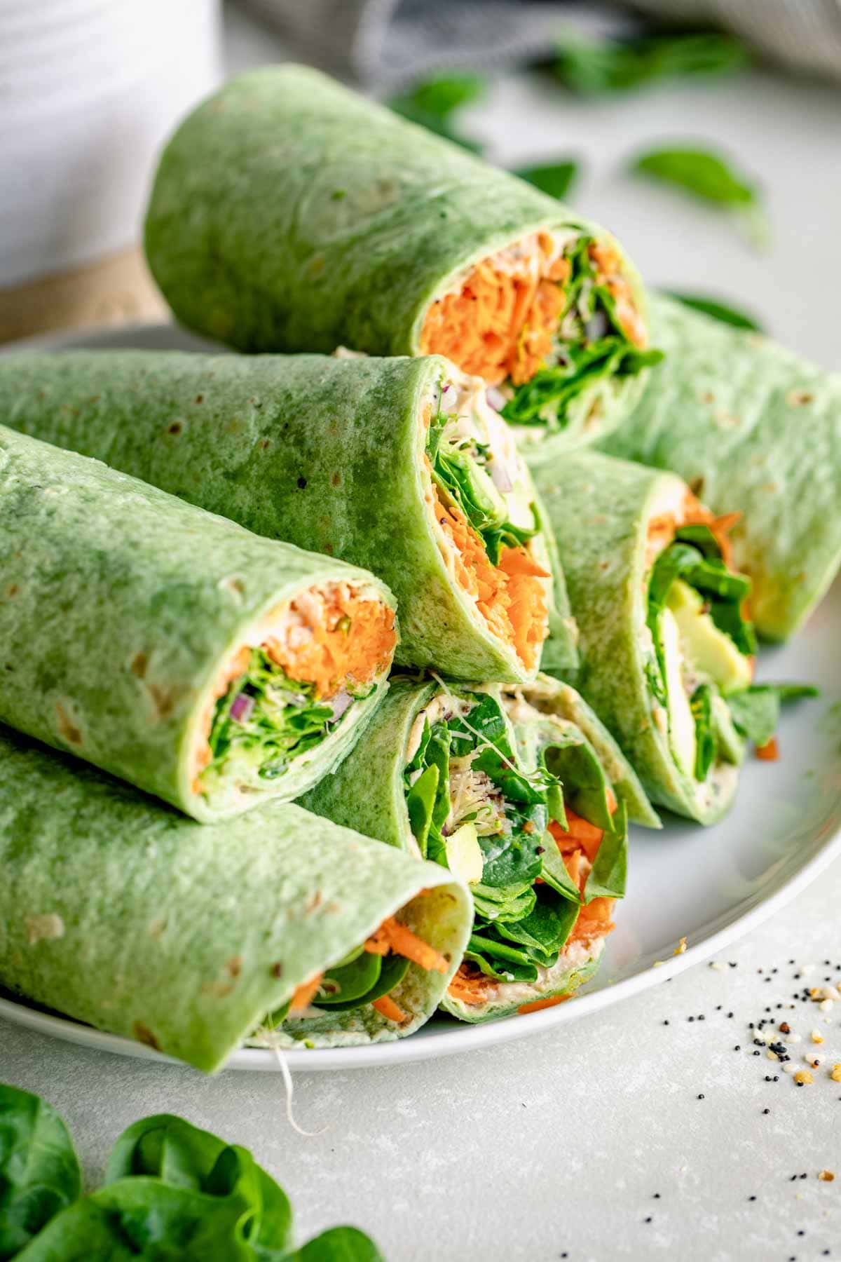 a platter with several veggie wraps piled on top of one another