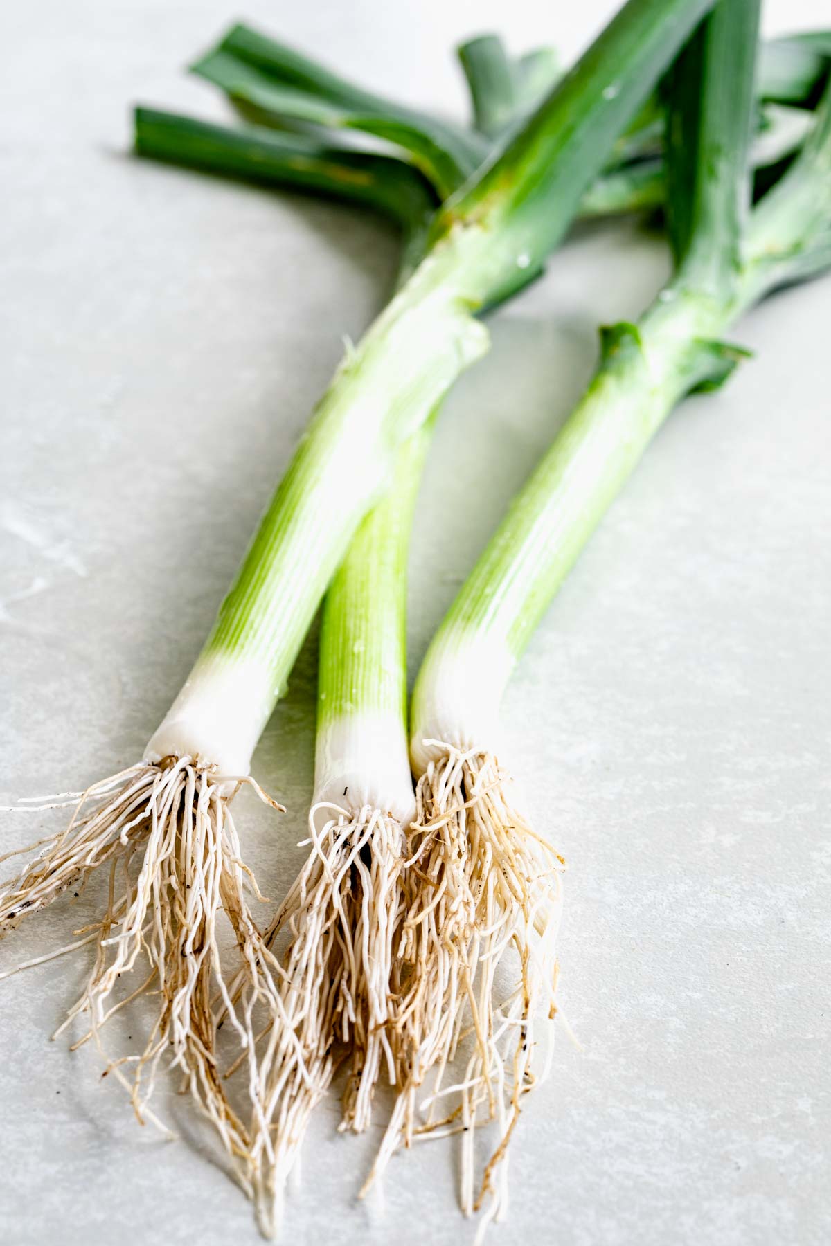 three leeks on a white table