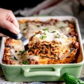 ground turkey lasagna slice on a spatula with the lasagna in the background