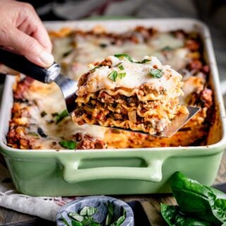 ground turkey lasagna slice on a spatula with the lasagna in the background