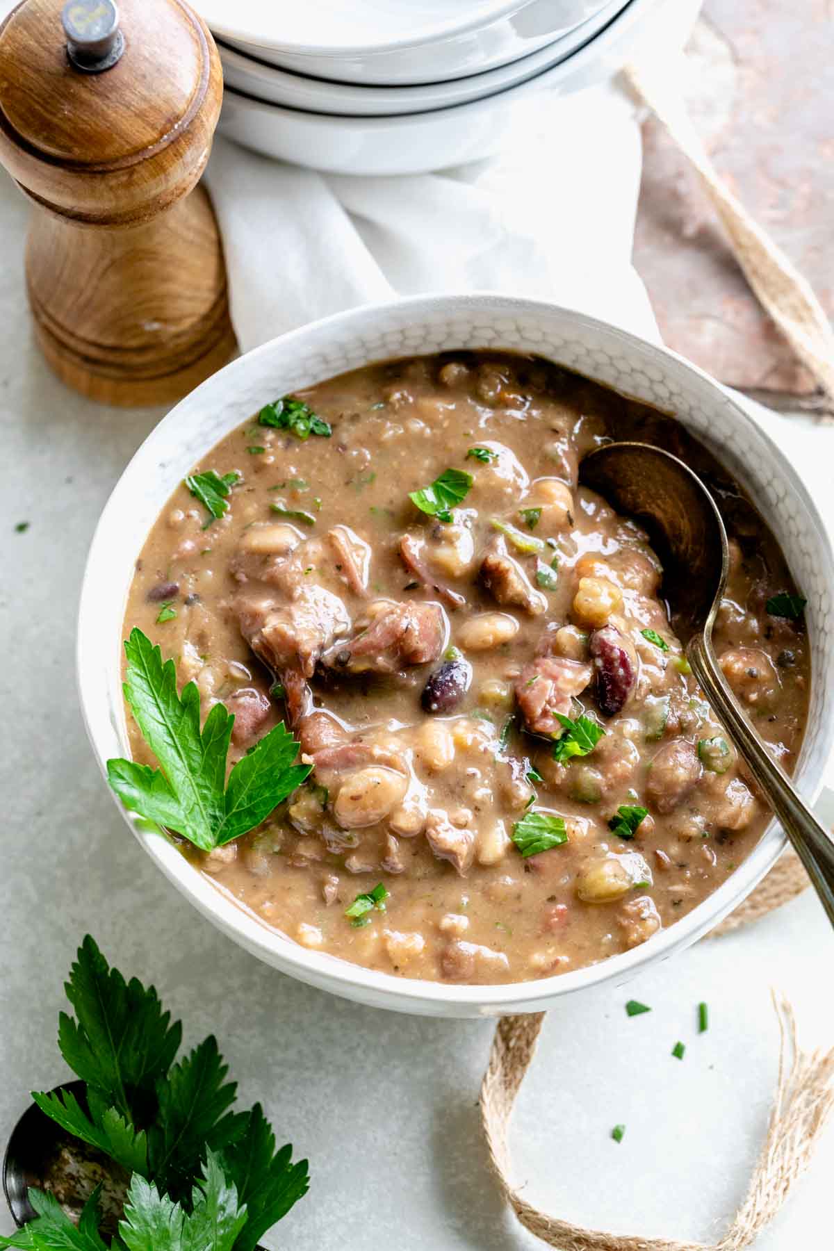 ham and bean soup in a bowl with a soon sitting on the side
