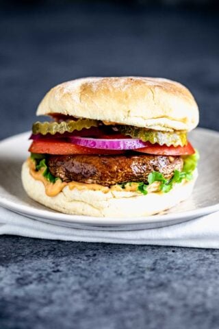 portobello mushroom sandwich with burger toppings on a plate