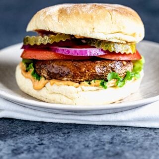 portobello mushroom sandwich with toppings on a bun