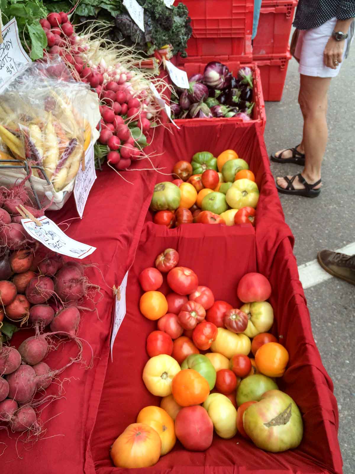 a farmers' market stall with yellow and red tomatoes