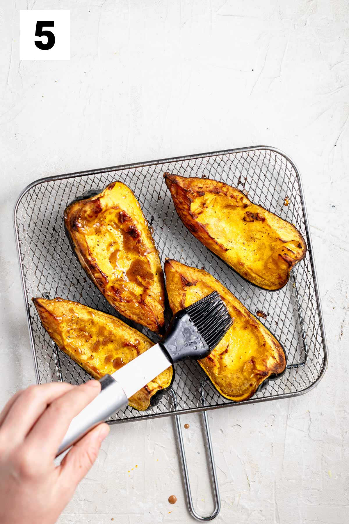 brushing air fried acorn squash with honey
