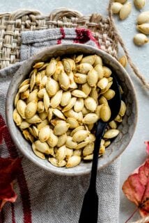 a bowl with baked pumpkin seeds in it