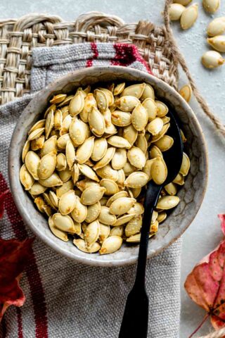 a bowl with baked pumpkin seeds in it