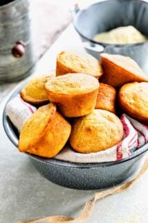 muffins in a metal bowl with a kitchen cloth