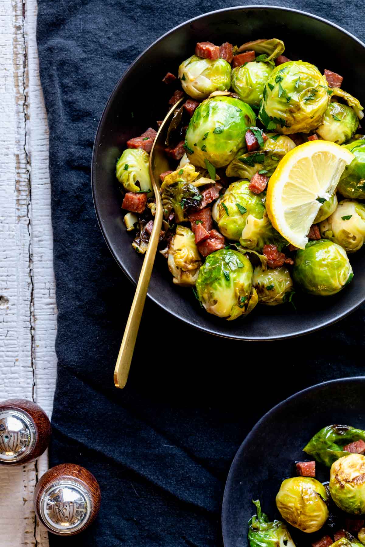 a black bowl with Brussels in it with a gold spoon