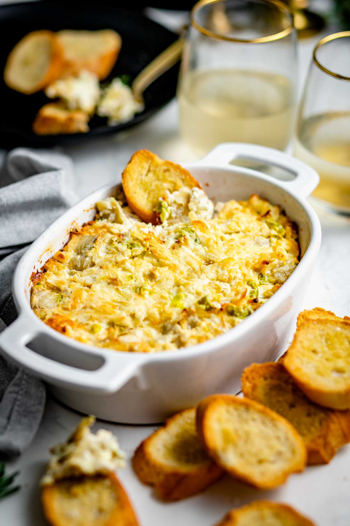 baked dip in a crock with crostini around it