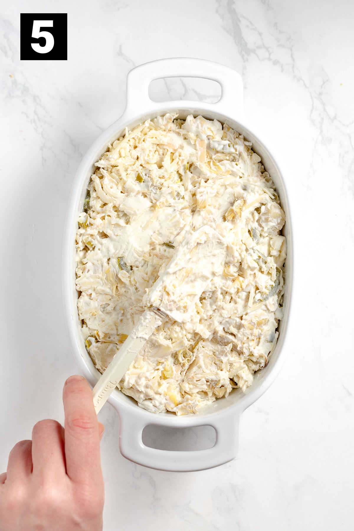 spread the artichoke dip into the casserole dish
