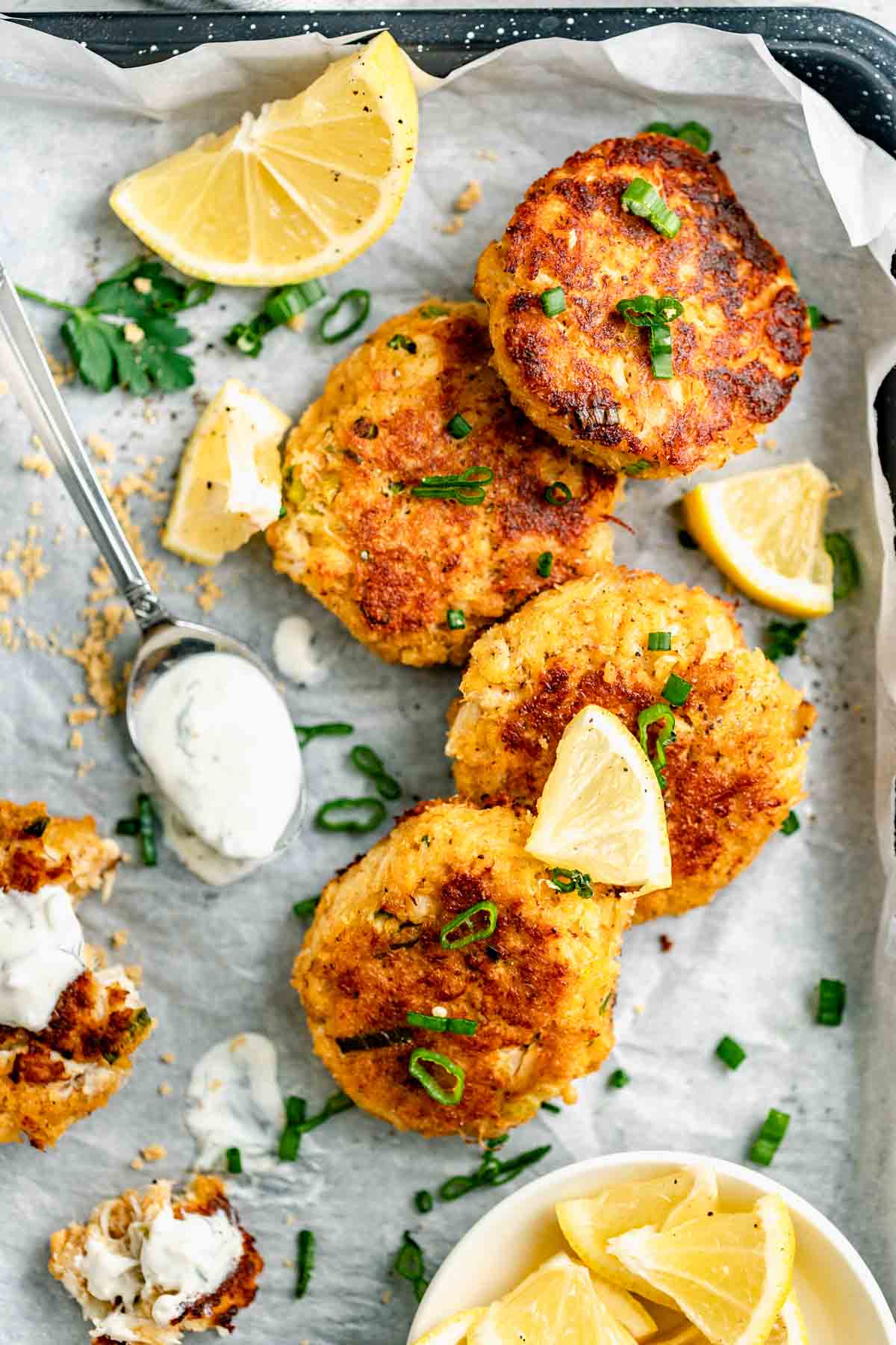 healthy crab cakes with tartar sauce and lemon slices