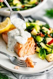 creamy dill sauce getting spooned over a piece of salmon