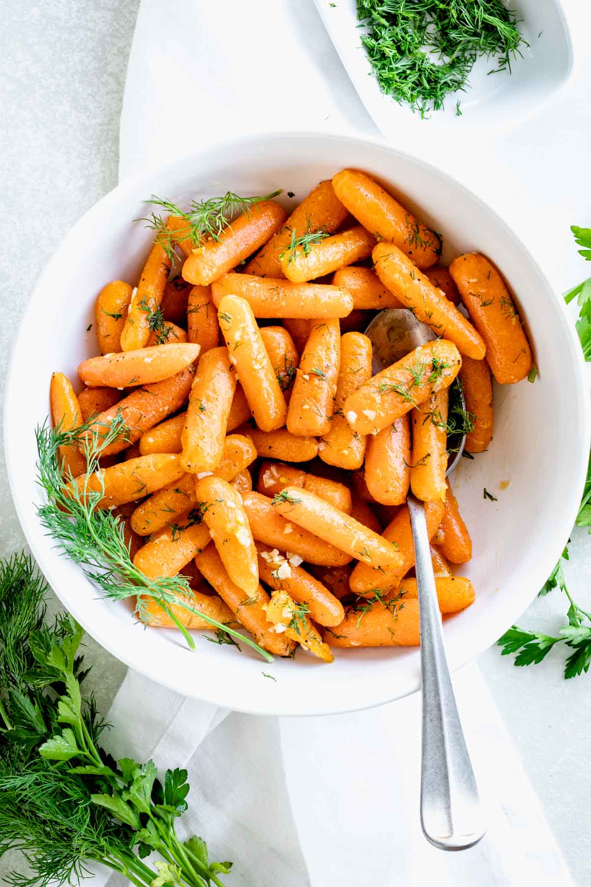 overhead view into the bowl of the cooked carrots with a spoon in it
