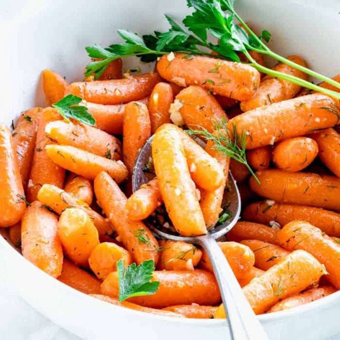 side view of the bowl of carrots with a spoonful resting on top