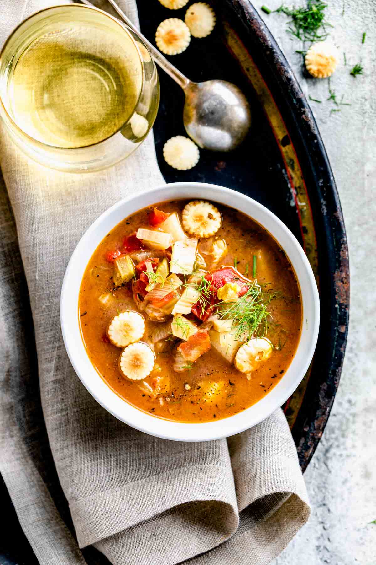 red clam chowder in a bowl with crackers on top and around