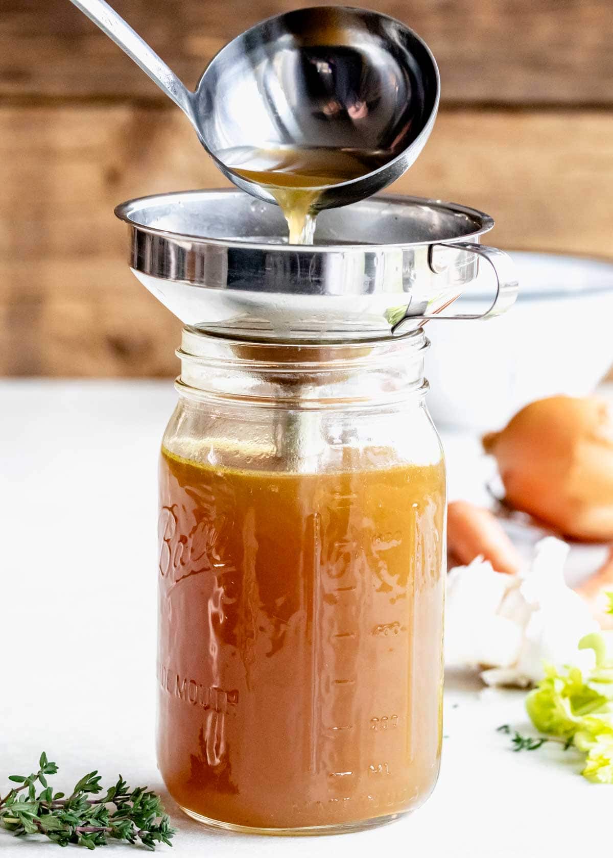 straining veggie stock into a mason jar