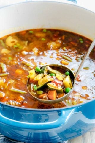 a blue pot with soup in it, and a ladle lifting a scoopful out