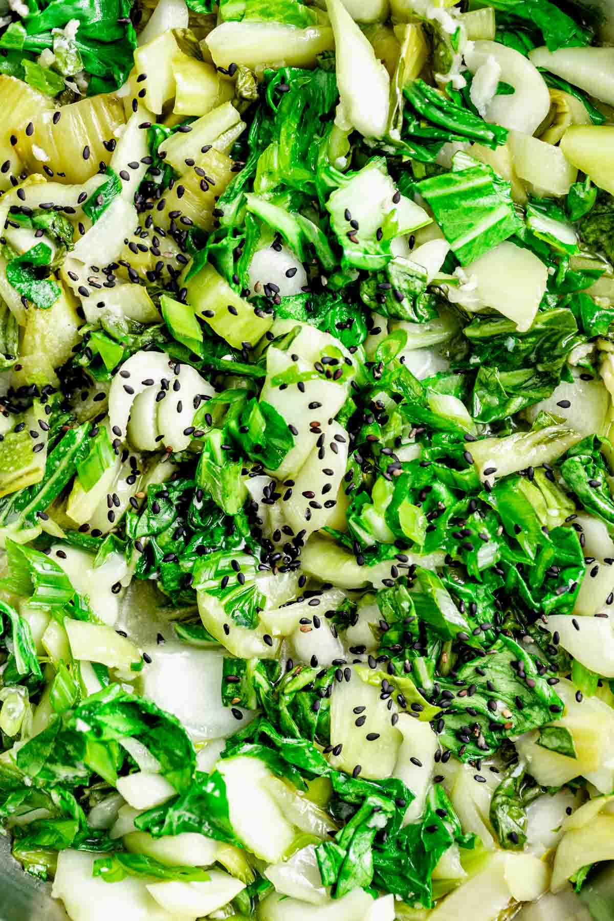 close up image of bok choy after being sauteed and sprinkled with sesame seeds