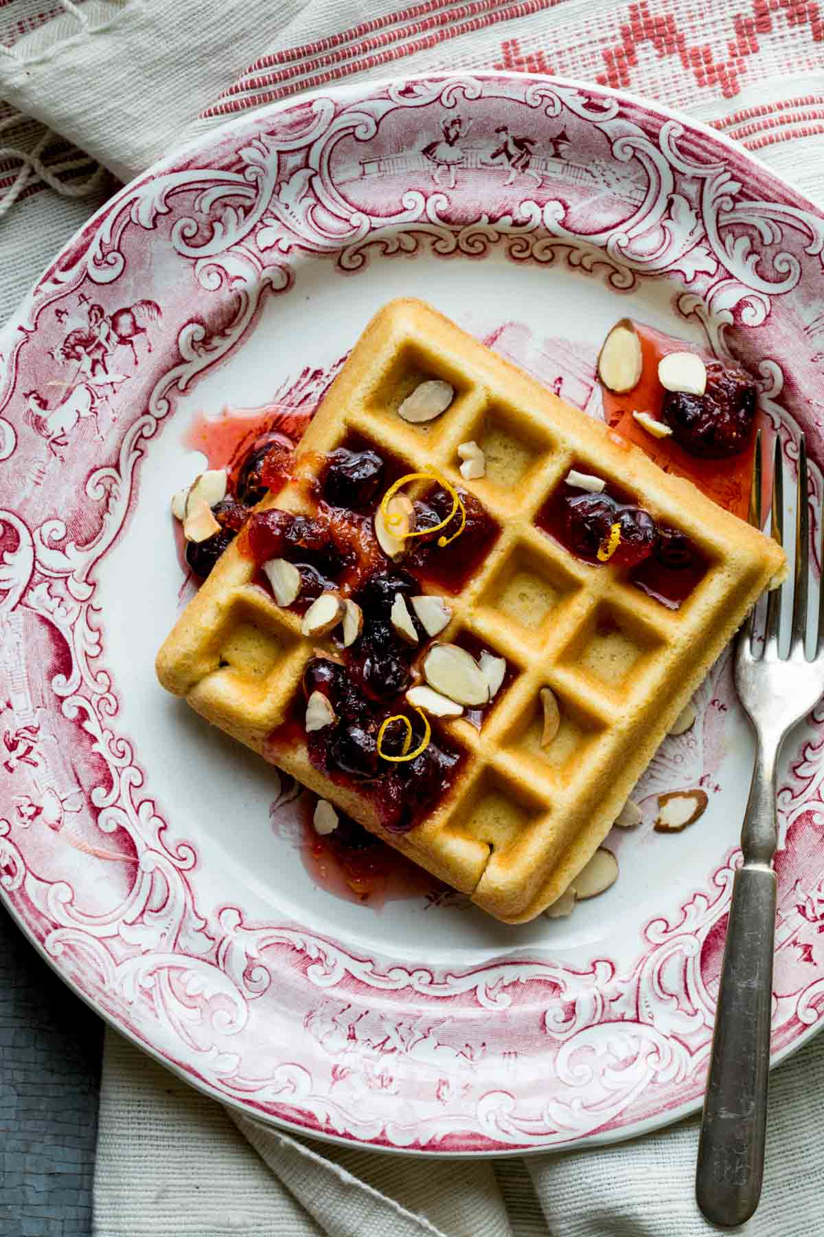 one serving of the waffles on a red and white plate