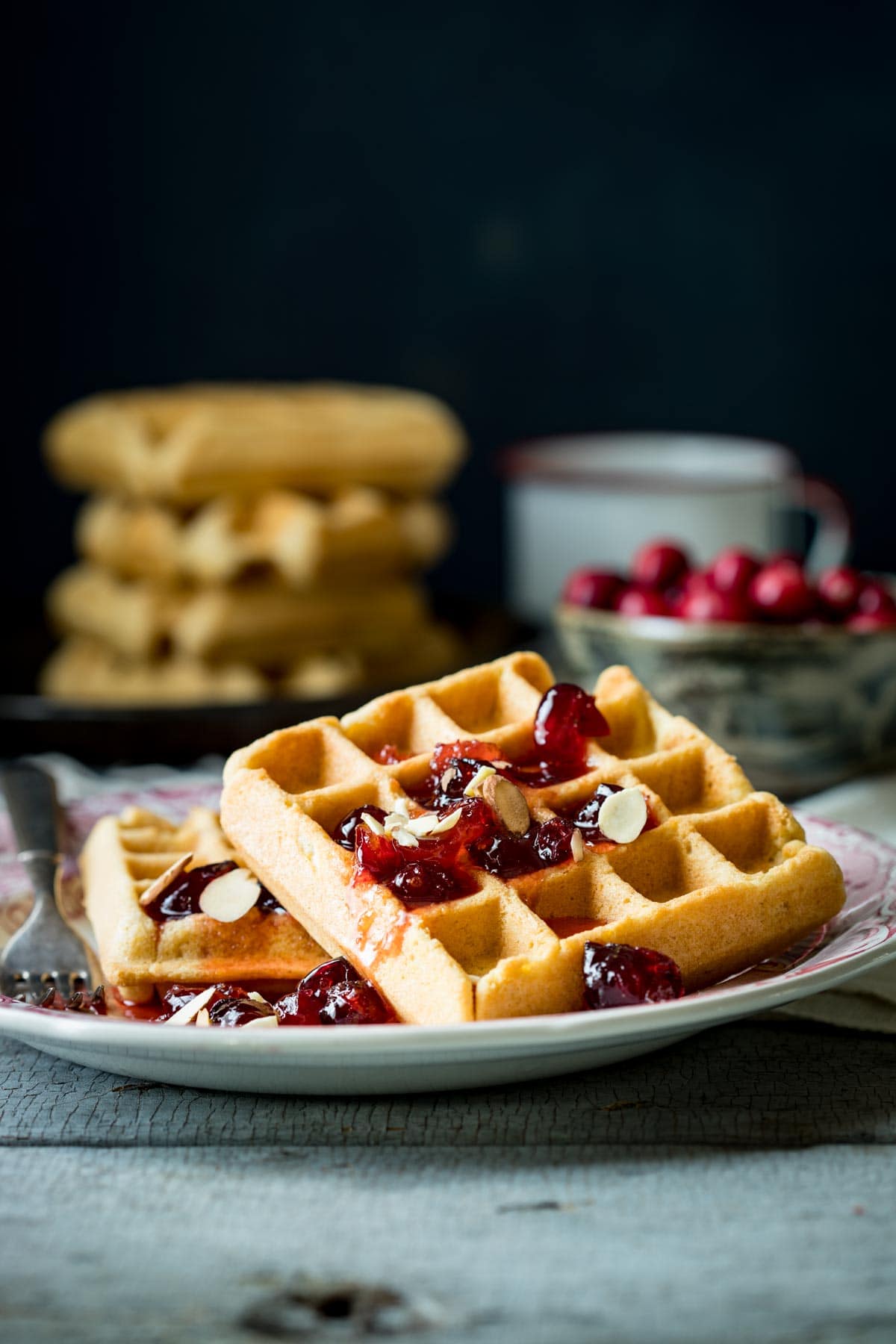 the cranberry almond waffles on a plate from the side