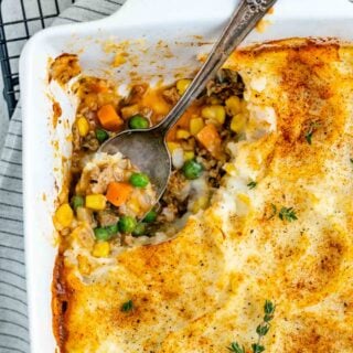 ground turkey shepherd's pie with a spoonful scooped out of the corner of the casserole dish with the spoon in the empty spot
