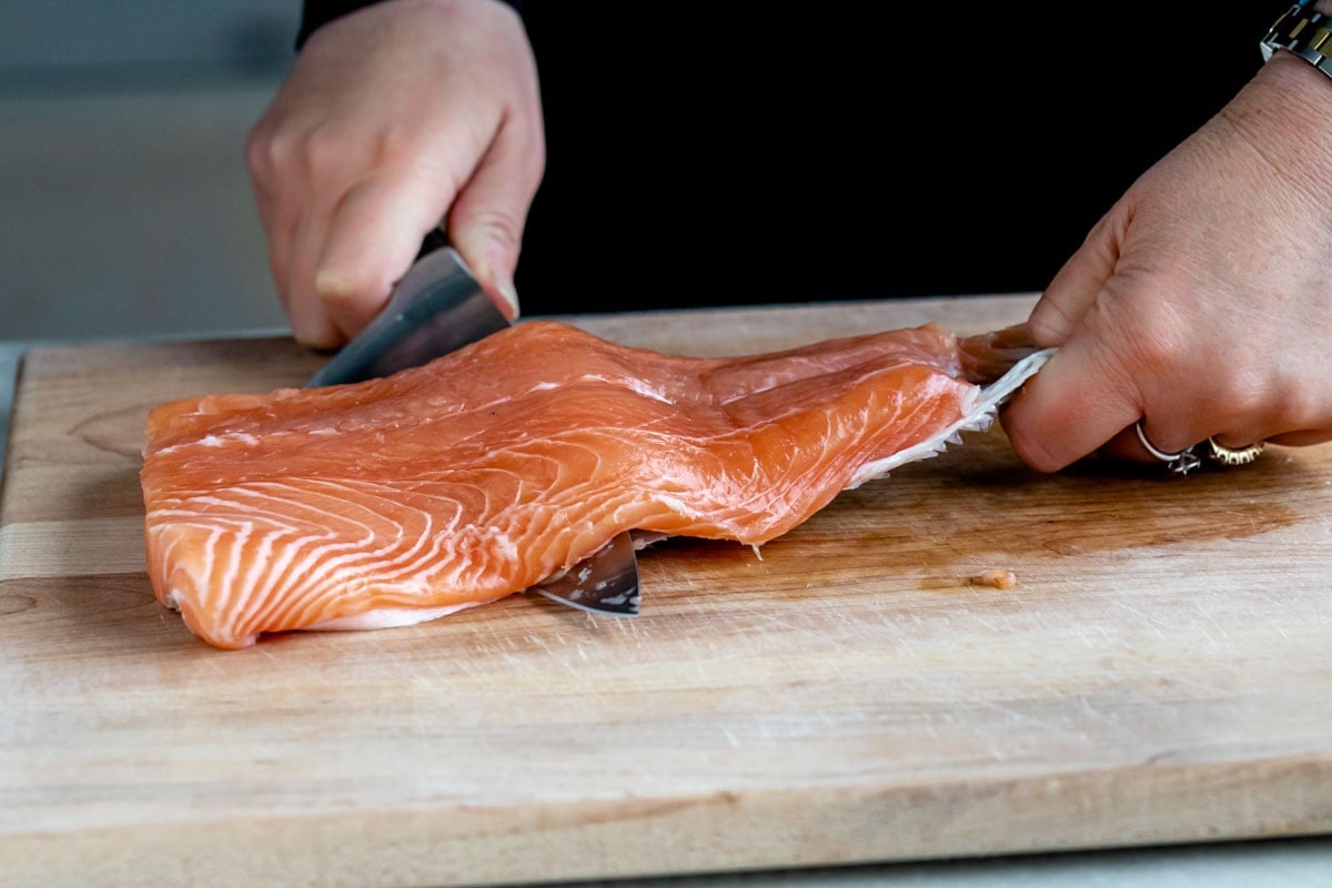 pressing the knife downward and pulling the skin back